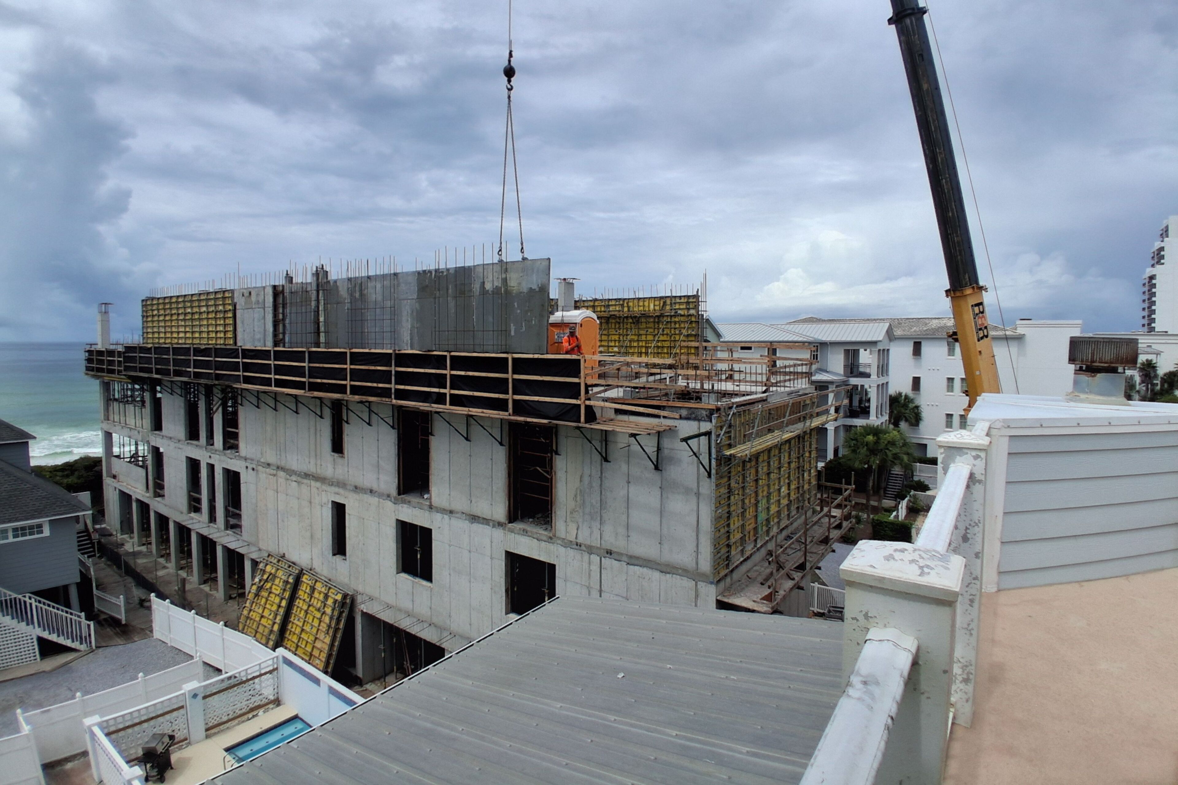 A multi-story building under construction with visible scaffolding and a crane.