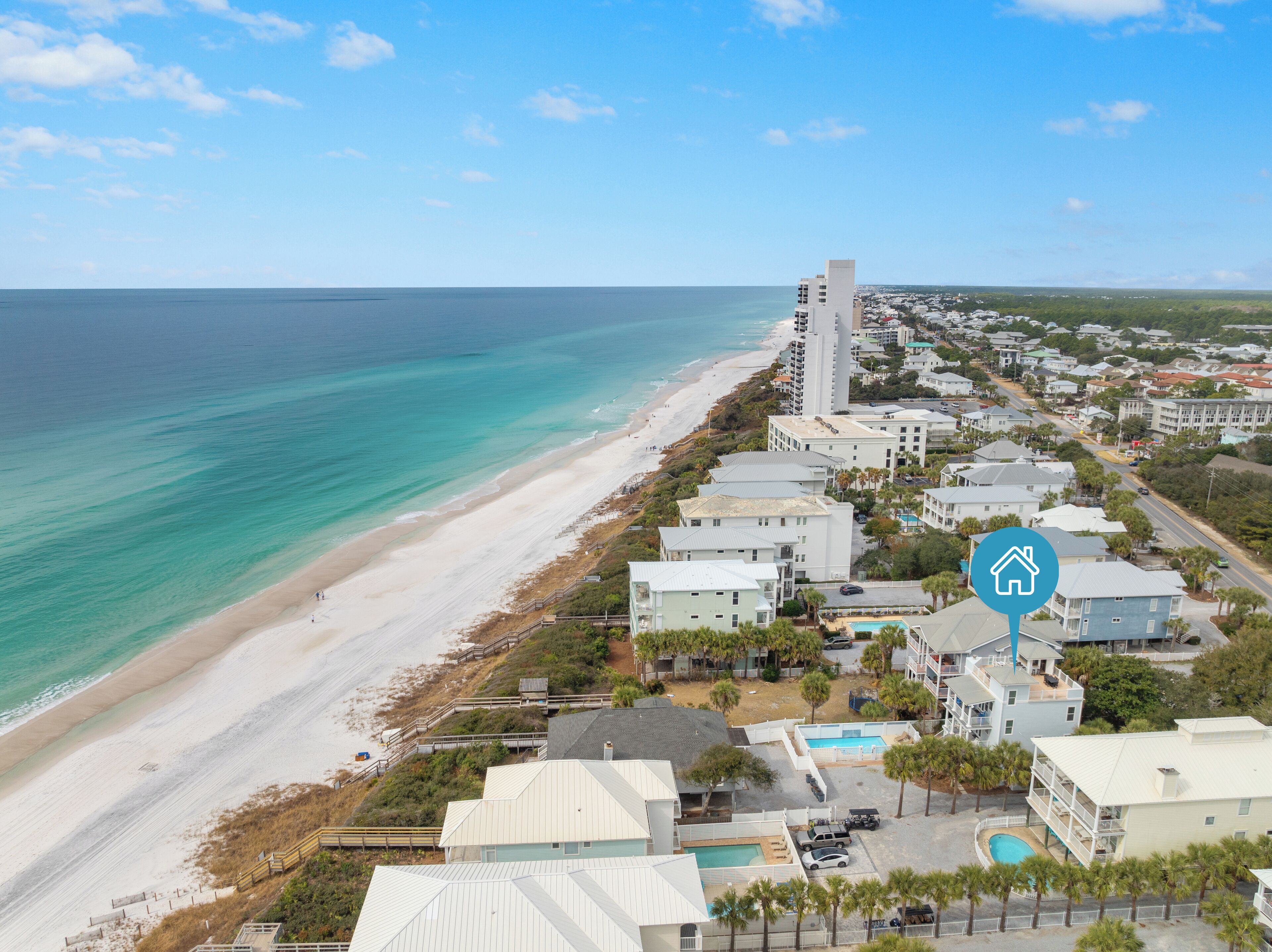 A coastal hotel with a beach view, multiple buildings, and a swimming pool.
