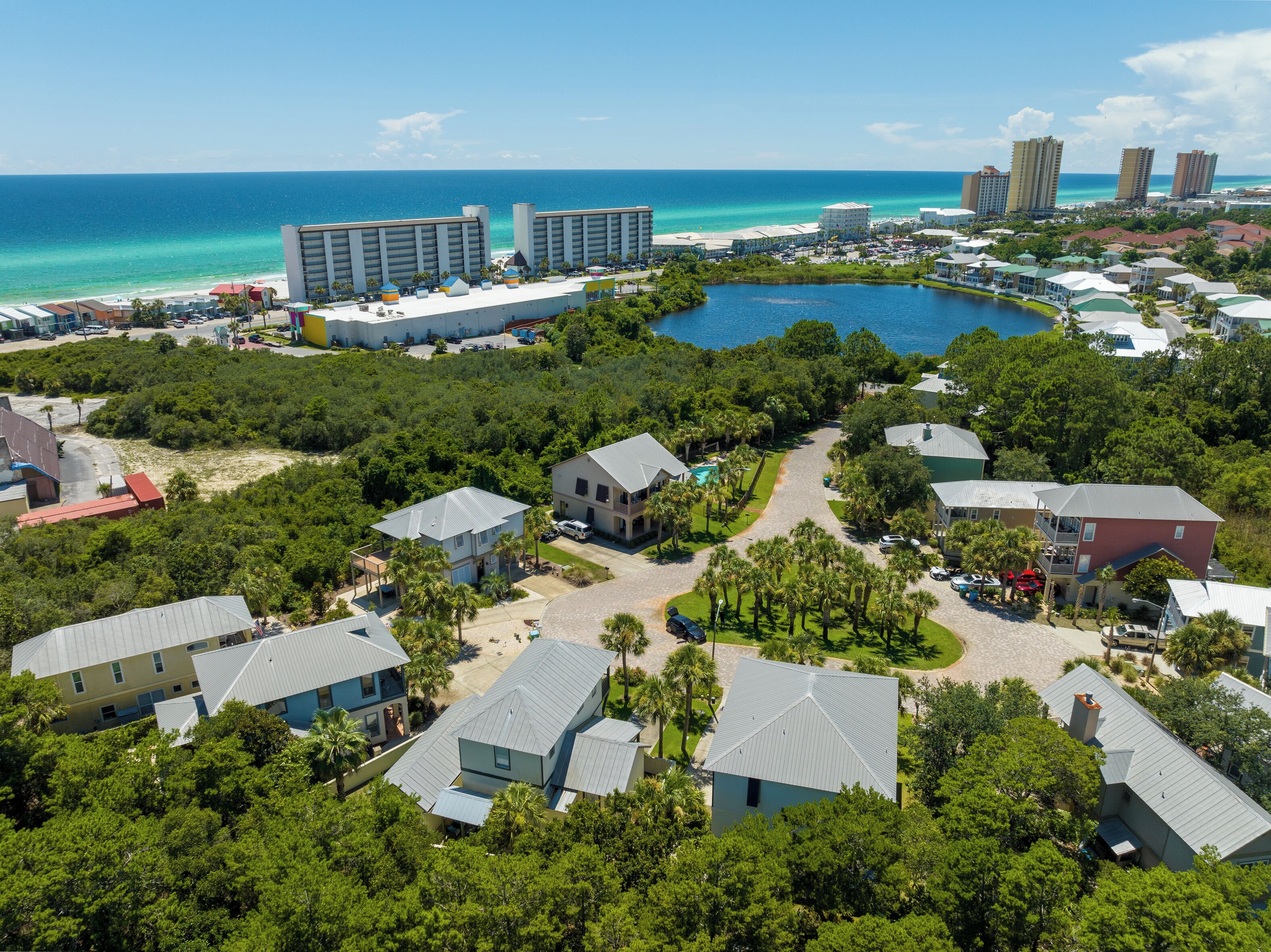 A resort with a central pool, beachfront buildings, and dense greenery.