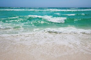 Een strand met golven die op het strand breken.