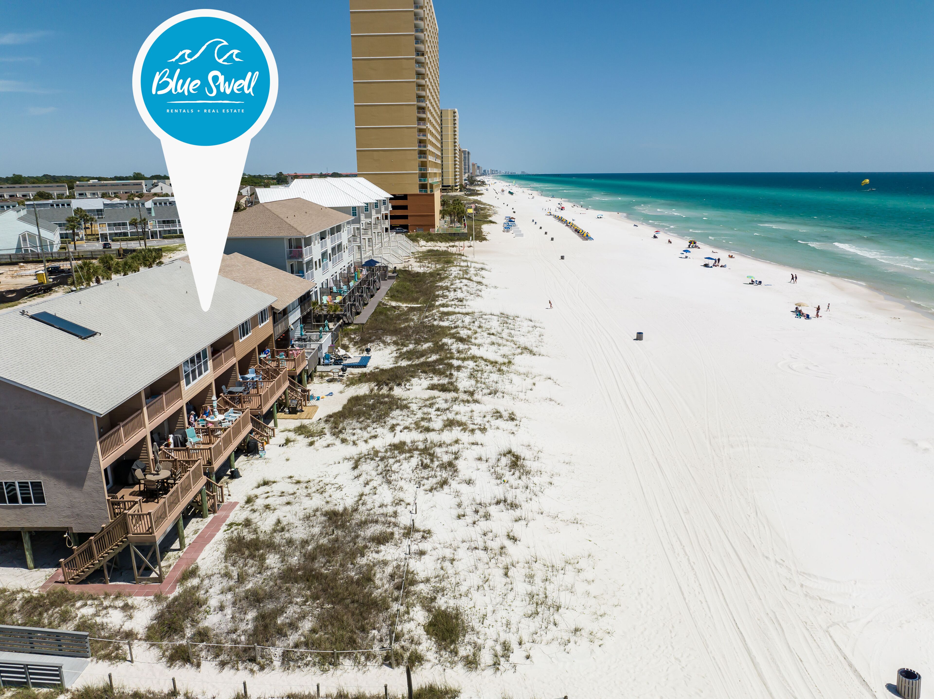 Een strandhotel met een promenade, toegang tot het strand en uitzicht op de oceaan.