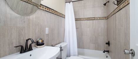 Un baño con lavamanos, inodoro y bañera.