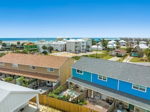 A residential area with houses, a wooden fence, and a clear view of the ocean.