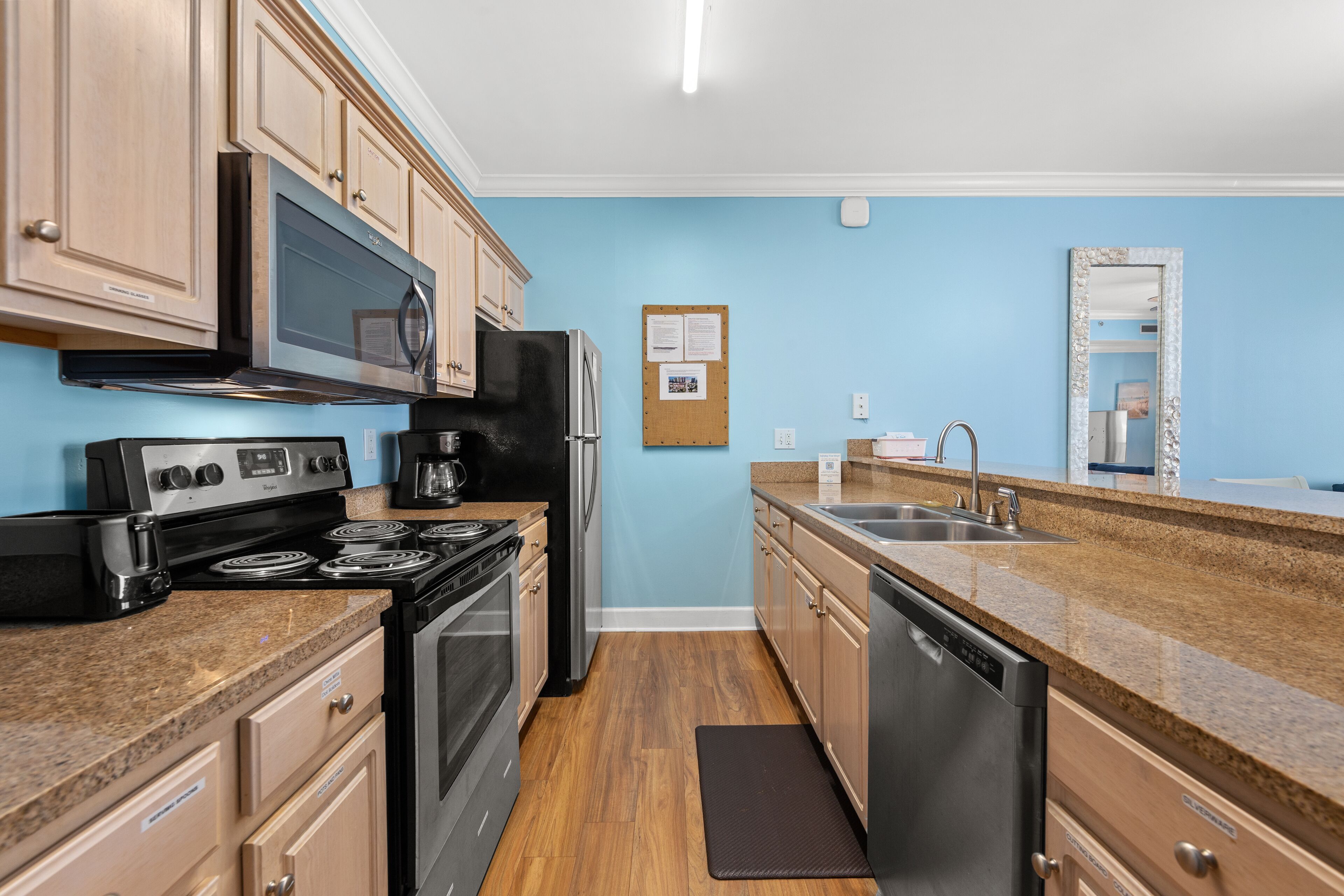 A kitchen with wooden cabinets, a stainless steel stove, a microwave, and a dishwasher.