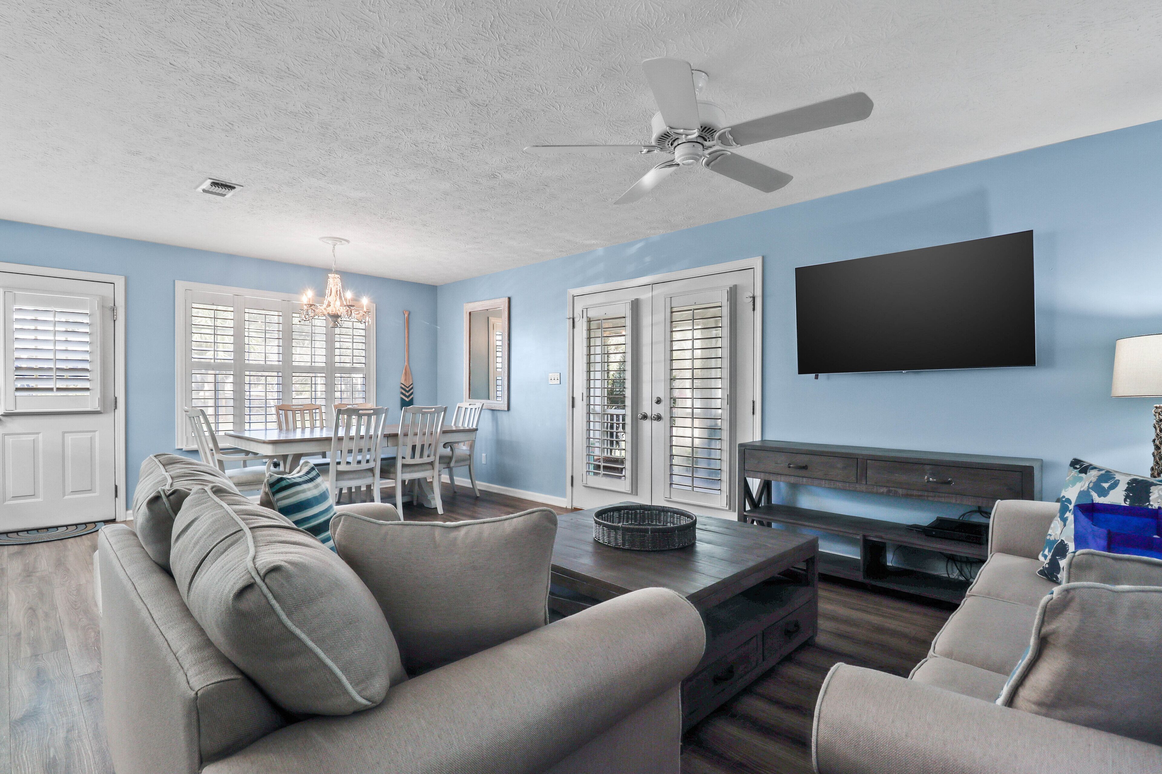 A living room with a sofa, TV, and dining area.