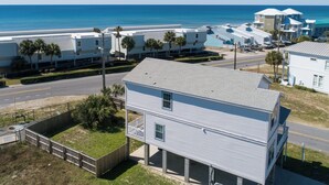 A coastal residential area with beachfront properties, including a two-story house with a balcony and a row of mobile homes. - Summer Dayz - Families Love It Here, Just Across From the Beach (Panama City Beach)
