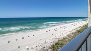 A beach view with a clear sky, a sandy beach, and a row of beach huts. - The Perfect Escape! Long Beach Resort-8th Floor-gulf Front With Amazing Views (Panama City Beach)