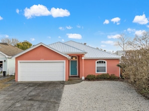 Einbungalow mit Garage, Eingangstür und kleinem Fenster.