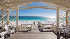 A beach view from a wooden deck with white railings and chairs. - A Seaside Beauty! Book Now - Lot of Outdoor Living Space (Santa Rosa Beach)