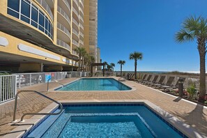 Relax by the pool surrounded by palm trees and lounge chairs.