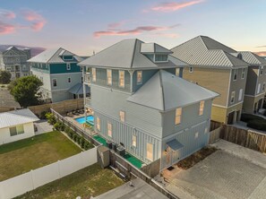 A multi-story residential building with a swimming pool, a fenced backyard, and a view of neighboring houses. - Three Master Bedrooms! Easy Beach Access! Gulf Views (Panama City Beach)