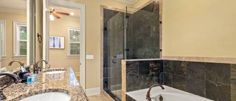 Une salle de bain avec deux vasques, une douche à l’italienne et une grande baignoire.