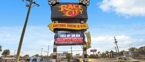 A sign for Race City with a haunted house advertisement.