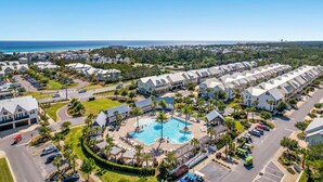 Eine Vogelperspektive eines Resorts mit einem zentralen Pool, mehreren Gebäuden und freiem Blick auf den Ozean.