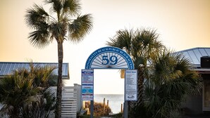 A beach entrance sign with palm trees and a view of the ocean. - Across Street From Beach - Close to Pier Park - Sleeps 6! (Panama City Beach)