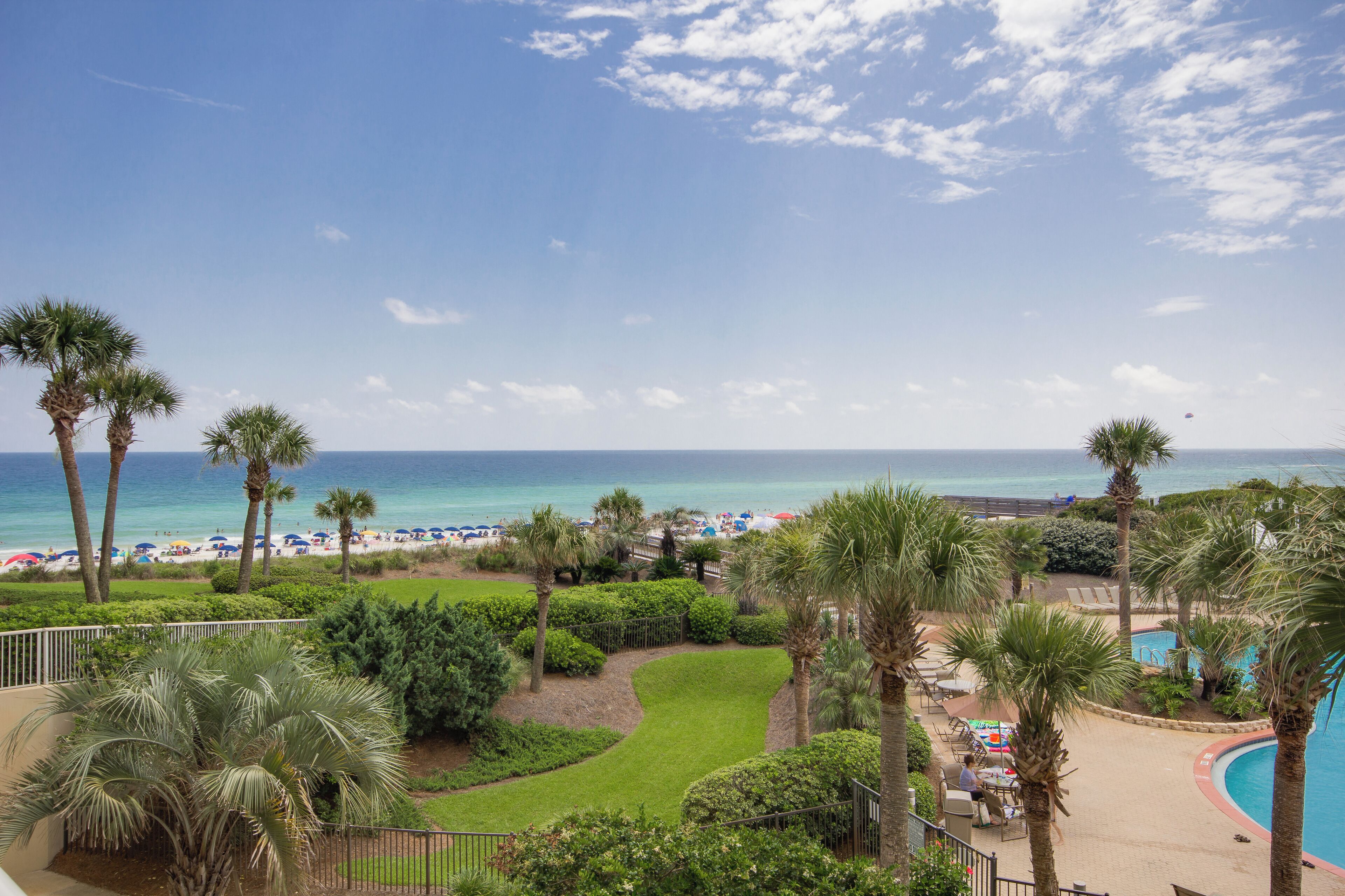 Ein Resort mit Pool, Palmen und Blick auf Strand und Meer.