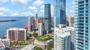 A high-rise hotel with multiple floors, a swimming pool, and a view of the sea. - Brickell Home with New Floors & Kitchen 41st Floor (Miami)