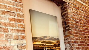 Una scala con un muro in mattoni e un quadro raffigurante un paesaggio.