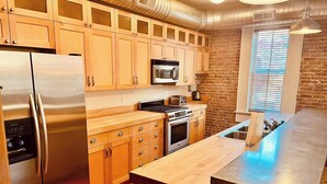 Una cucina moderna con mobili in legno, elettrodomestici in acciaio inossidabile e una grande isola.