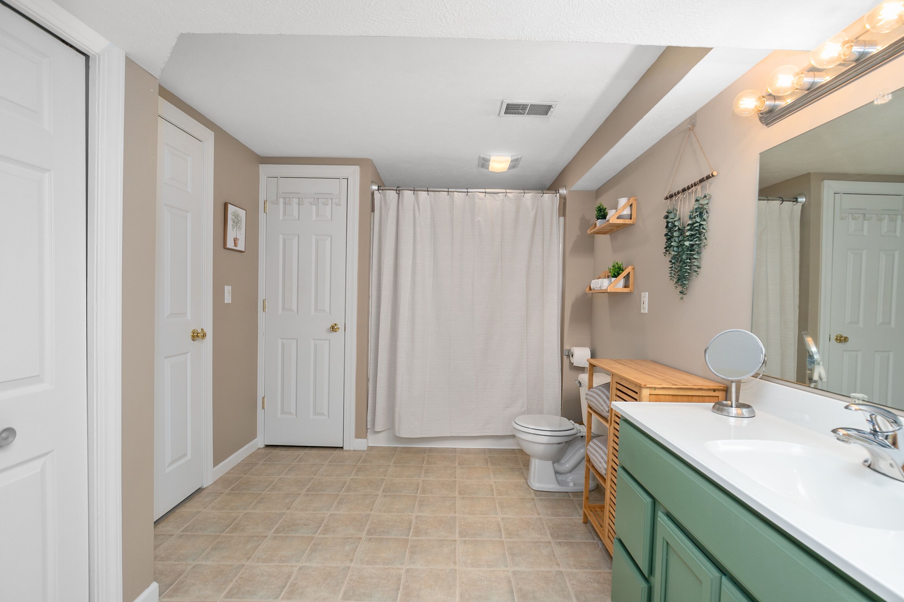 A bathroom with a toilet, sink, and shower curtain.