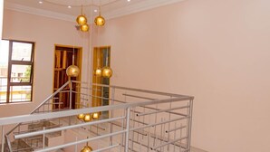A modern interior with a staircase, metal railings, and pendant lighting.