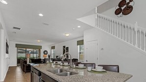 A modern kitchen with granite countertops, stainless steel appliances, and a built-in sink. - Paradise 6 BR home - private pool and spa near all Disney parks - Free pool heat (Kissimmee)