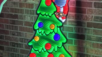 Adorno navideño con figura de Papá Noel, adornos y regalos.