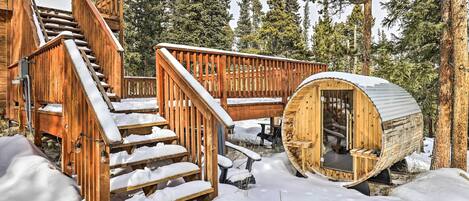 Una baita di legno con una scala a chiocciola, un'area esterna in legno e un'accogliente stanza in stile baita.