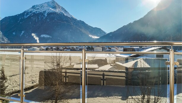Bergzicht vanaf een balkon met heldere lucht.