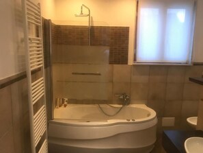 Appartement | Badkamer | Een bad/douchecombinatie, een regendouche, een bidet, handdoeken