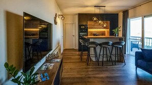 Una cocina moderna con una isla central, taburetes de bar y un espejo grande.