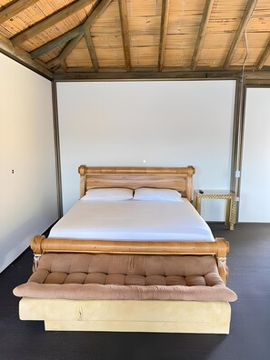 Cozy retreat with a single bed, wooden headboard, and sloped ceiling with exposed beams.