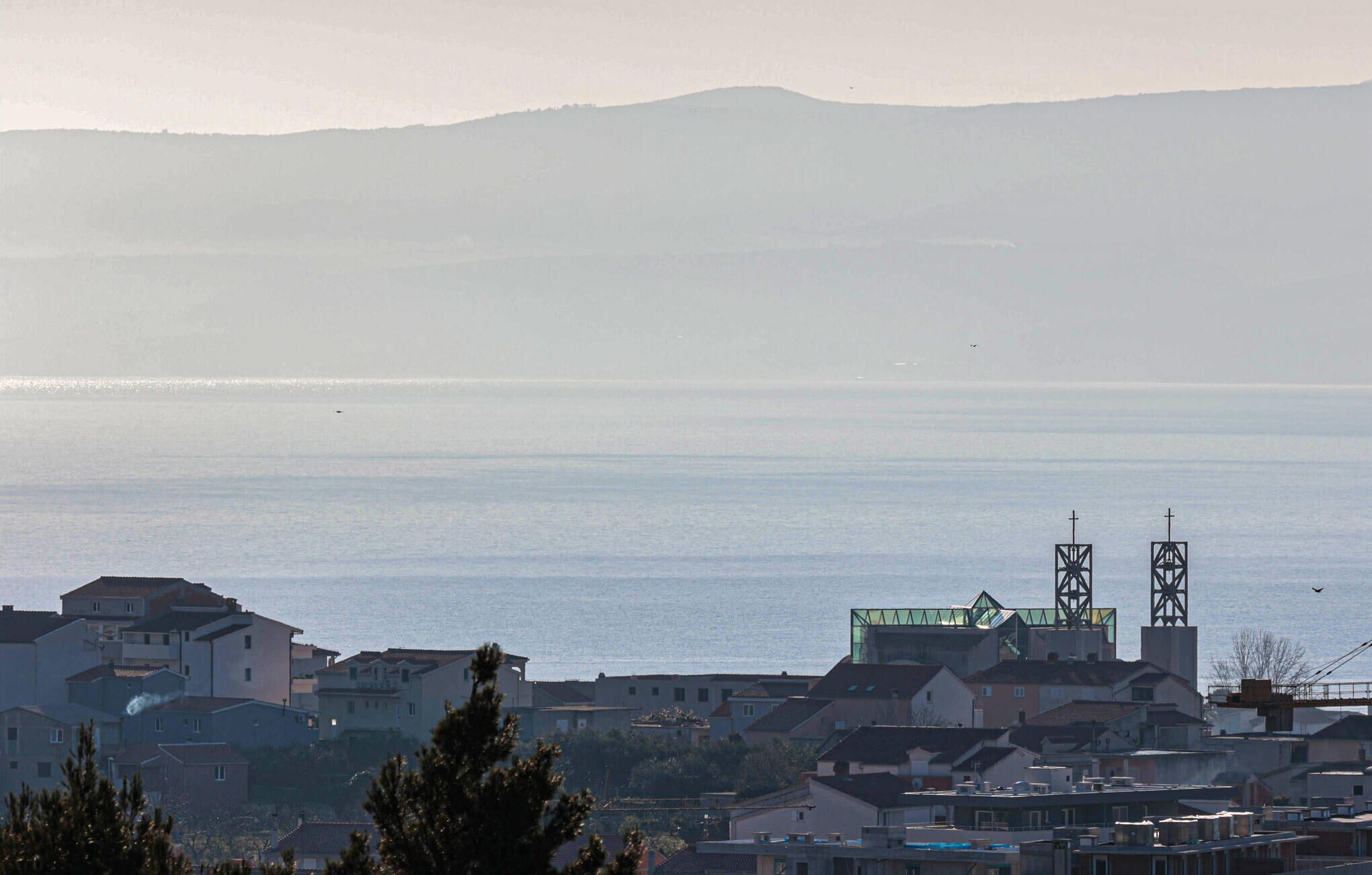 A coastal town with residential buildings and a clear view of the sea.