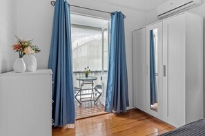 Cozy retreat with a small table for two, a wardrobe, and air conditioning for a comfortable stay.