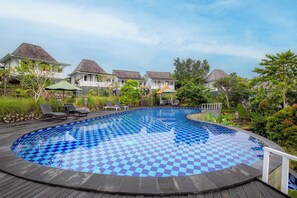 A checkered pool surrounded by lounge chairs and a deck, with overhanging trees and a clear sky. - The Kleep Jungle Resort (Penida Island)