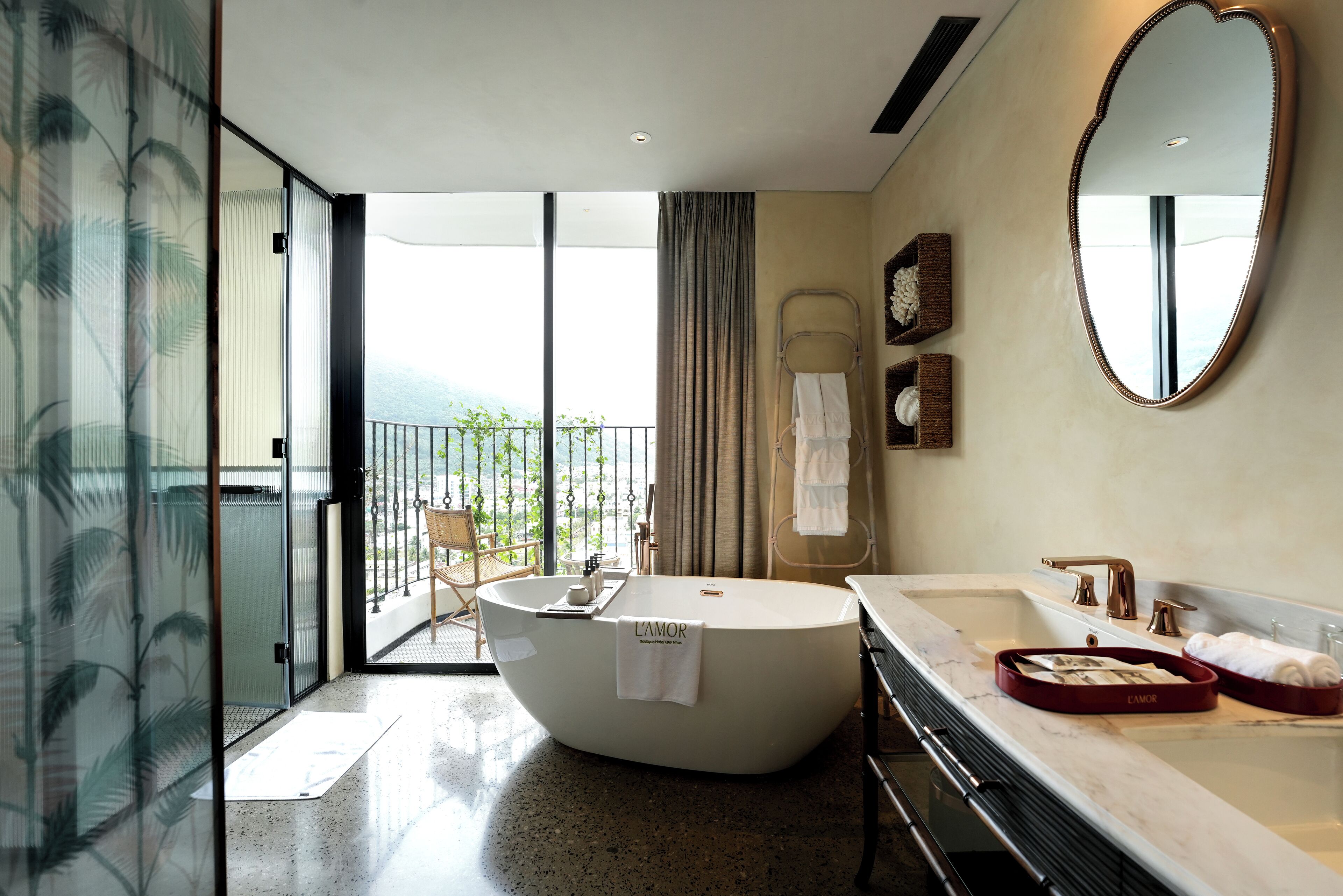 A modern bathroom with a freestanding bathtub, a large mirror, and a view of the outdoors.