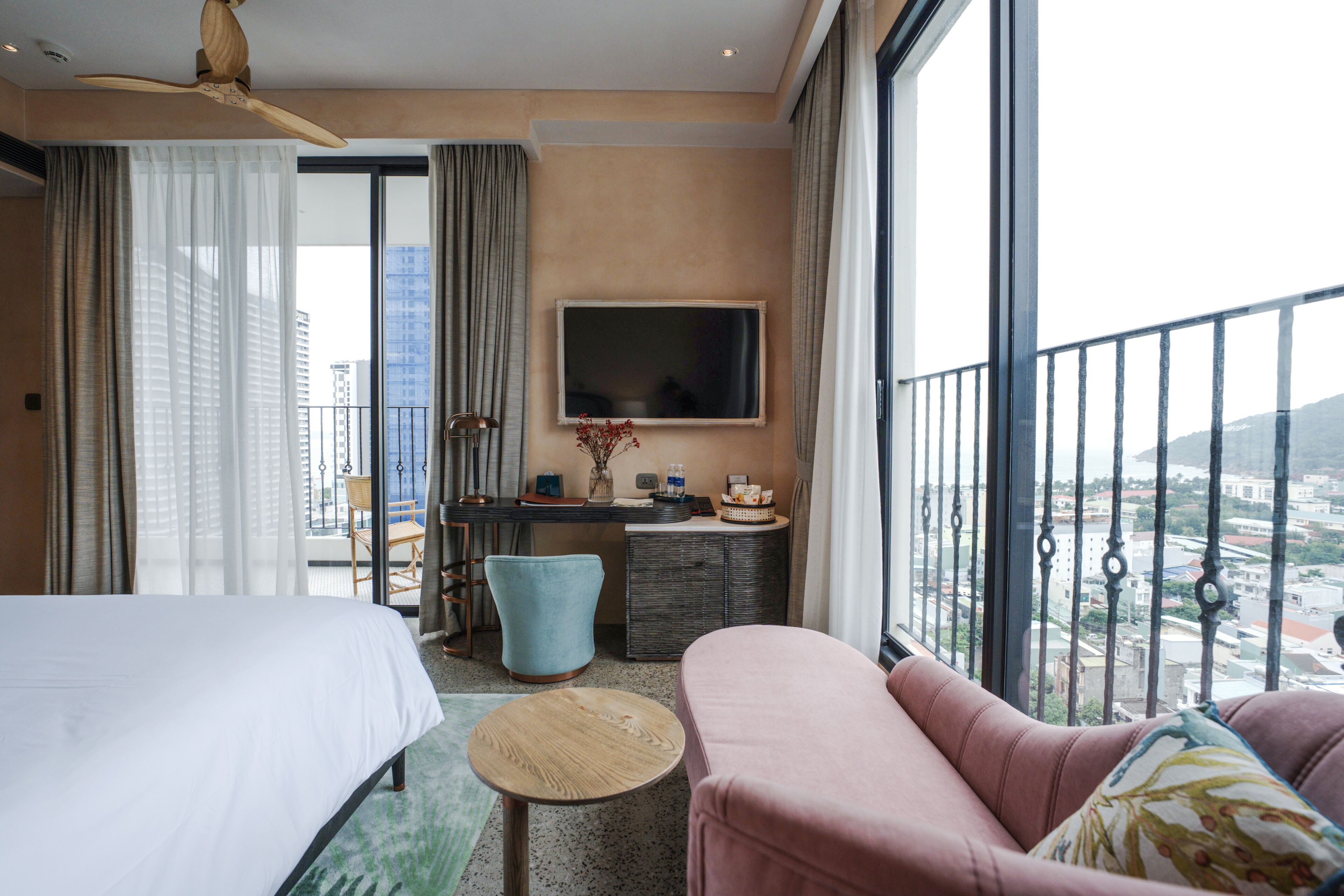 Ein Hotelzimmer mit Bett, Sofa, Schreibtisch und Fernseher.