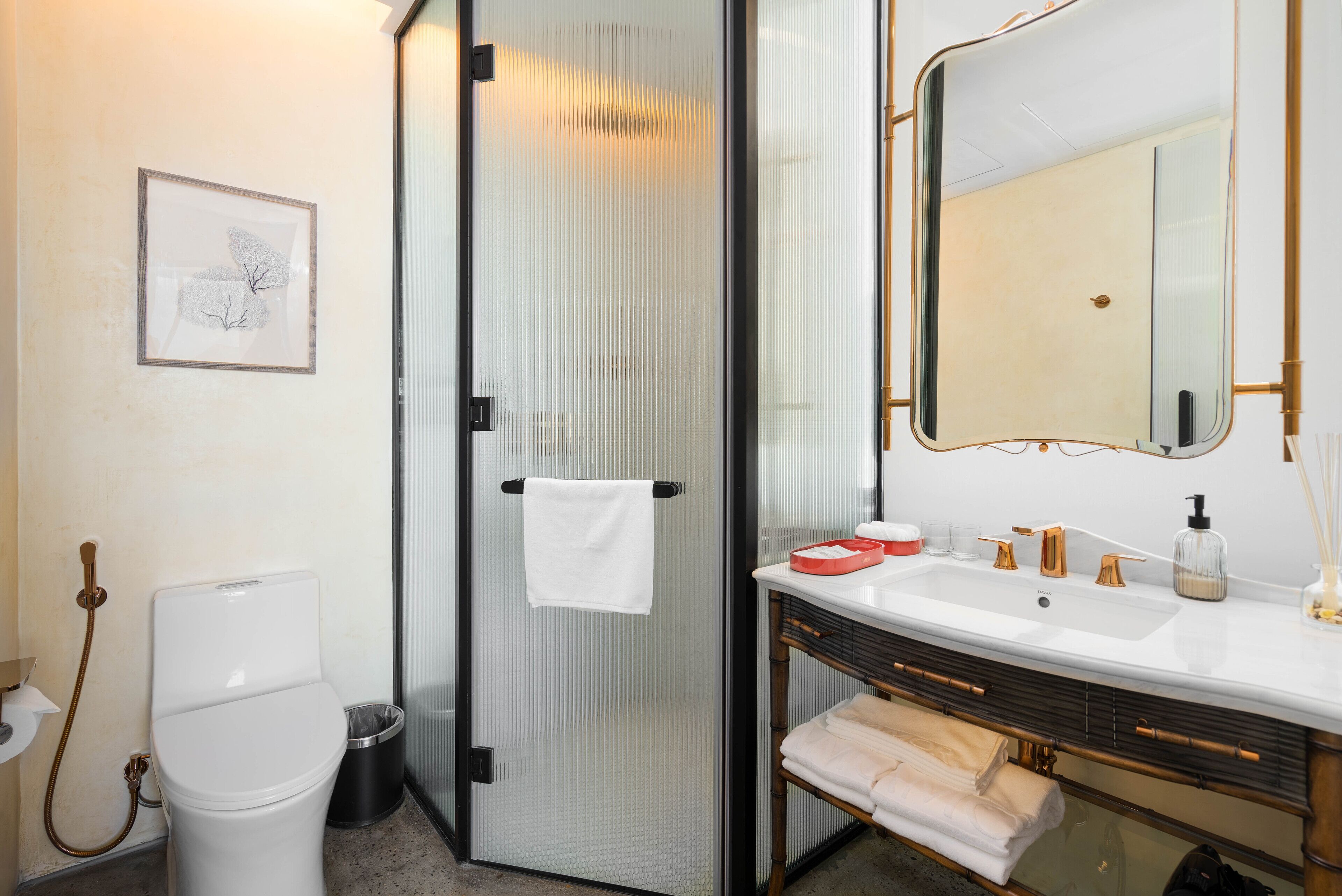 A modern bathroom with a toilet, shower, sink, and a large mirror.
