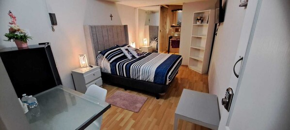 A compact bedroom with a bed, bedside table, lamp, and a small desk with a chair. - Habitaciones Narvarte Del Valle (Mexico City)