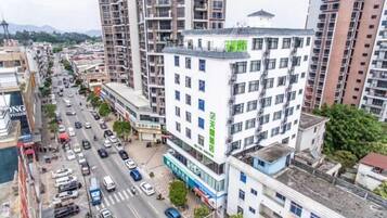 A multi-story building with a commercial ground floor, surrounded by a busy street with vehicles and pedestrians.