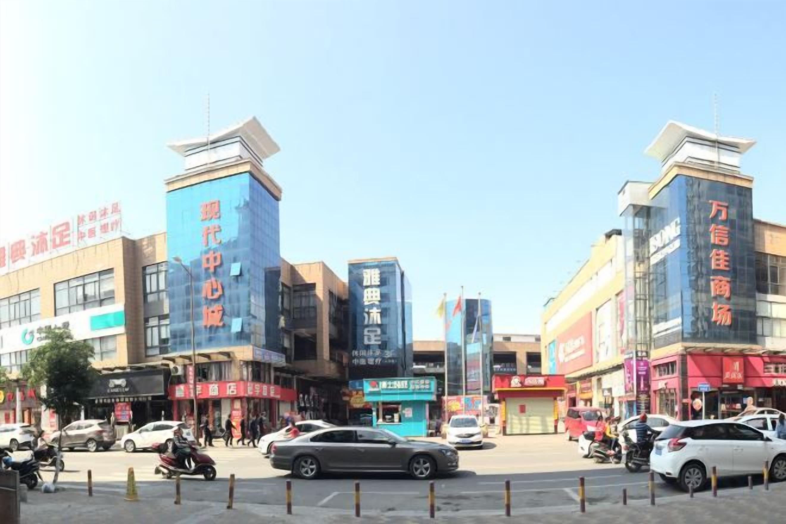 A commercial area with multiple storefronts, a pedestrian crossing, and vehicles.