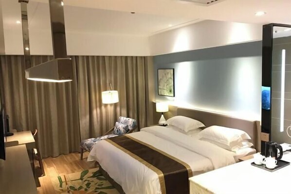 A hotel room with a bed, bedside tables, a desk, a chair, a lamp, a painting on the wall, and a television. - Insail Hotels Loufu Mountain Branch (Boluo)