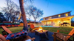 Un jardin avec un foyer extérieur, des sièges et une piscine.