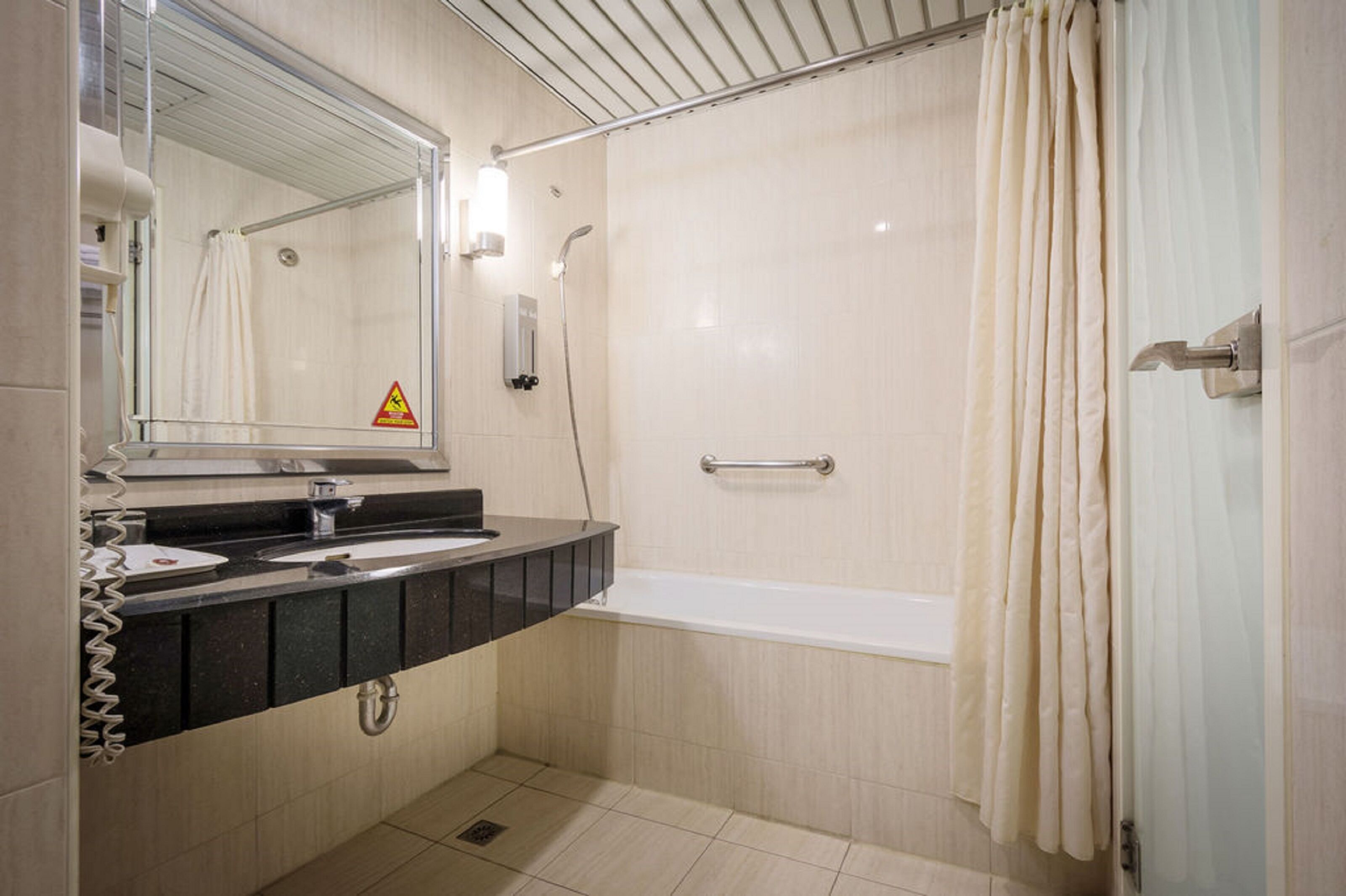 Un baño moderno con bañera, ducha y tocador con espejo.