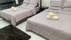Two twin beds with matching bedding, a dark rug, and a nightstand with a lamp. - ZaraVip Homestay (Ipoh)