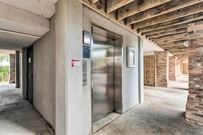 Ein Aufzug in einem Gebäude mit freiliegenden Holzbalken und Backsteinwänden.