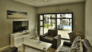 Ein Wohnzimmer mit Flachbildfernseher, Couchtisch und zwei Sofas.