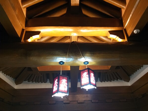 A wooden ceiling with a traditional design, including a sloped roof and decorative beams. - HanokInn (Gyeongju)