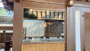 A traditional wooden structure with a built-in seating area and a view through a glass window.