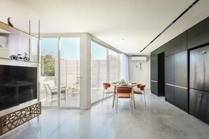 Une cuisine moderne avec un coin repas, de grandes fenêtres et une vue sur l’extérieur.